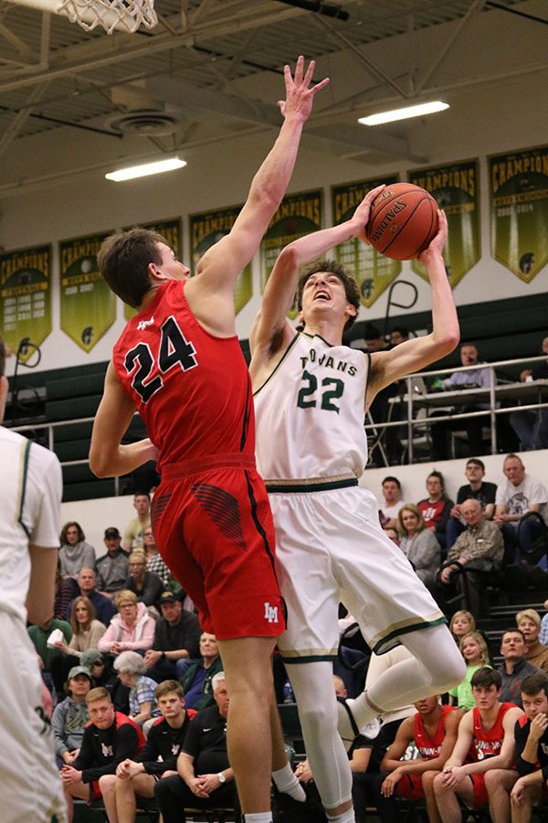 Patrick McCaffery 19 jumps up to make a shot as Linn-Mars Hayden Passmore 19 sticks his hand up in attempt to block it during the first half on Friday, Jan. 4.