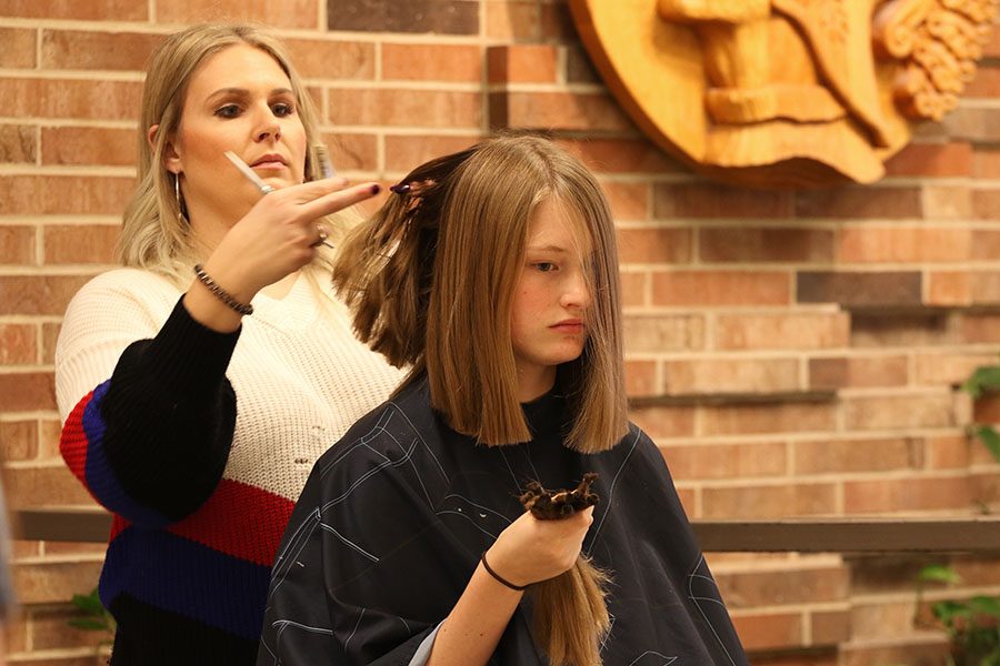 Rebekah Longmire 22 holds strands of her hair as the hair stylist trims the remaining hair during seventh hour on Friday, Jan. 11.
