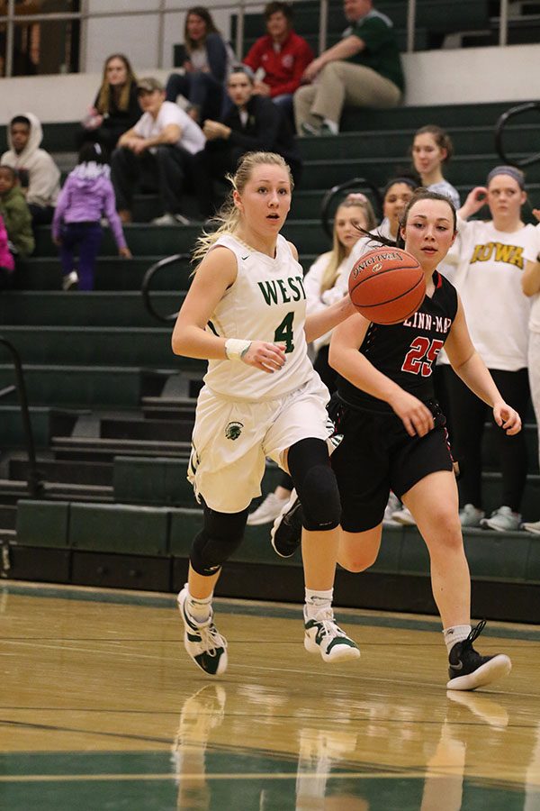 After stealing the ball, Lauren Zacharias 19 dribbles down the court during a fast break as Linn-Mars Emma Casebolt 21 attempts to stop her on Saturday, Feb. 16.