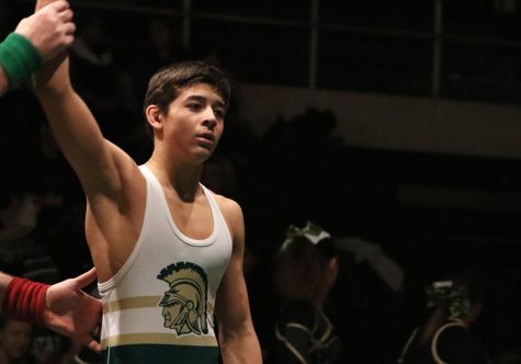 Hunter Garvin ’22 raises his hand victoriously in the air after defeating Dubuque Wahlert’s Colton Kisting ’22 on Jan. 17, 2019. Garvin wrestled at 120 pounds last season, but is making the jump up to 132 pounds this year.