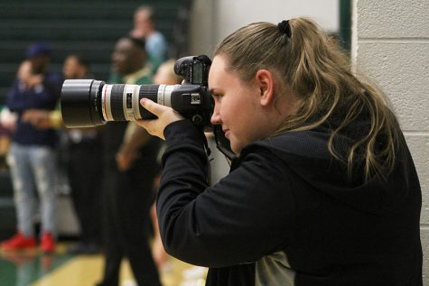 Online Editor-in-Chief and Co-Sports Editor Kara Wagenknecht 19 shoots a photo while covering a basketball doubleheader at West High on Saturday, Jan. 5.