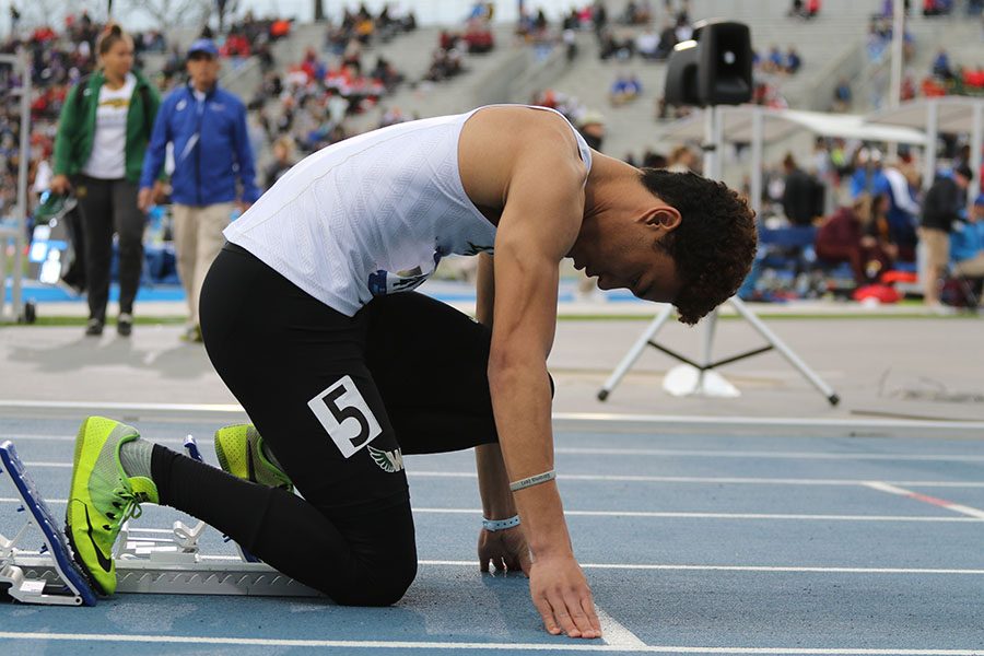 Gabe Caruthers 19 gets set in his blocks before his race on Friday, April 26. Caruthers placed fourth in a time of 49.12 in the first ever high school 400 meter dash at the Drake Relays.