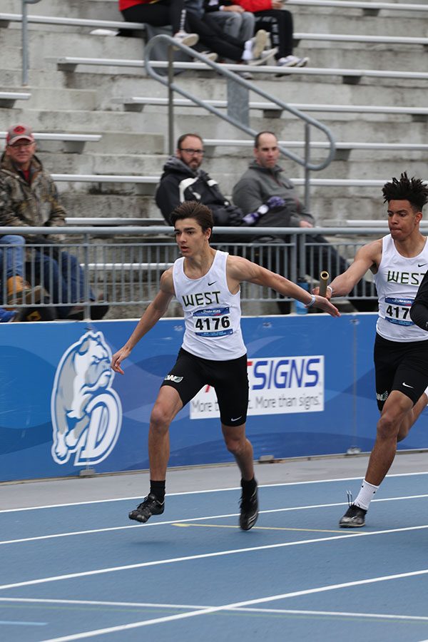 Shamar Wyatt 19 hands off the baton to Nate Gudenkauf 22 during the 4x100 meter relay prelims on Saturday, April 27. The relay team placed 35th in a time of 44.67.