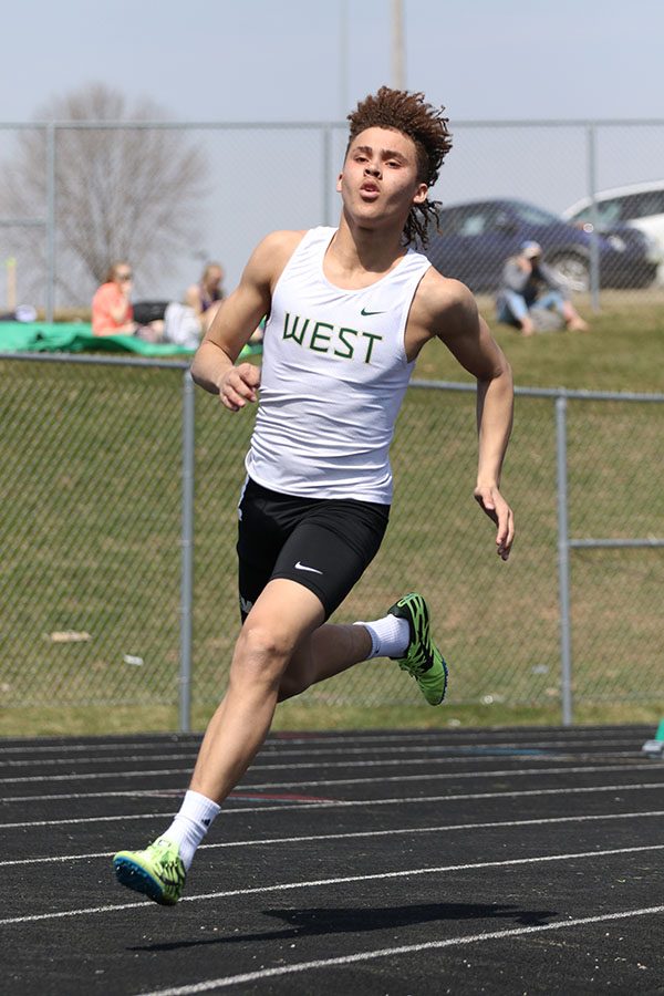 Tyuss Bell 21 runs around the curve of the track during the 400 meter dash on Saturday, April 6. Bell placed seventh in 52.54. He also competed in the 4x400 meter relay, 800 meter sprint medley relay and 1600 meter distance medley relay.