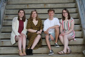Seniors Sophie Stephens, Lucy Polyak, Will Conrad and Maddi Shinall pose on a set of stairs downtown Iowa City on Sunday, May 5.