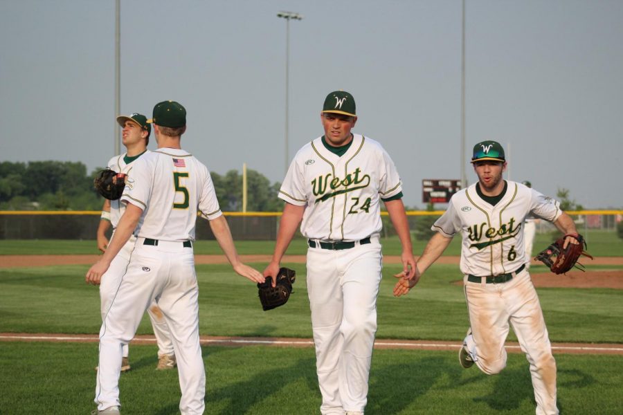 Owen McAreavy '19, Noah Aanestad '19, Nathan Wilkinson '19 and Nick Biancuzzo'19 run into the dugout during their game against Linn Mar on May 31.