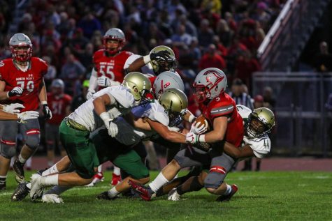 The West high defense makes a group tackle in the backfield during a game against North Scott on Aug. 30.