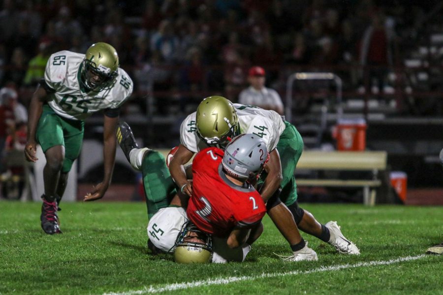 Mason Applegate '22 and Ali Alwahdani '20 sack the quarterback during a game against North Scott on Aug. 30.