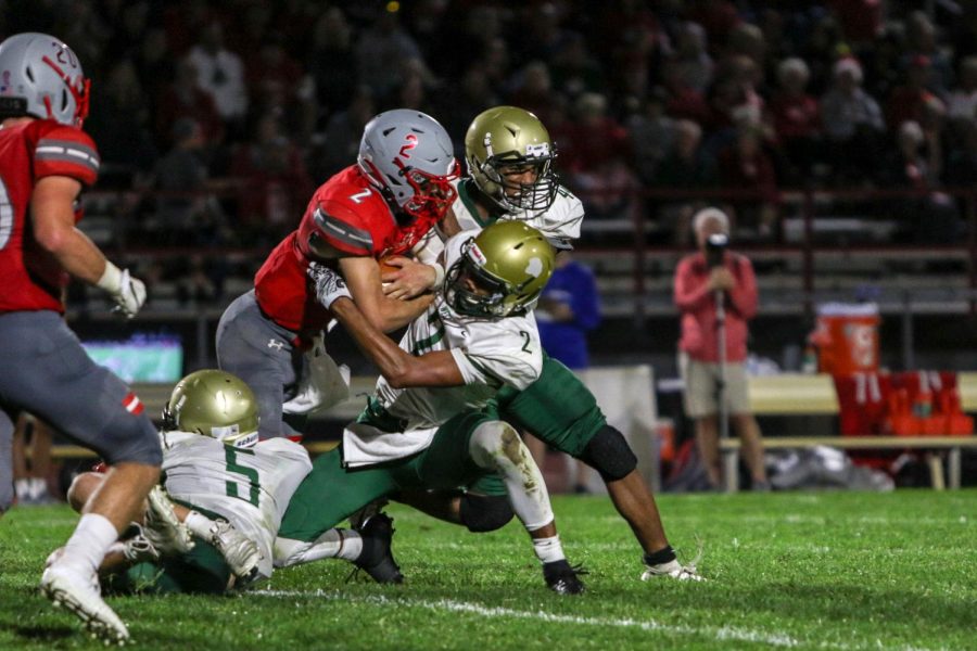 Marcus Morgan '21 and Mason Applegate '22 try to strip the ball during a game against North Scott on Aug. 30.