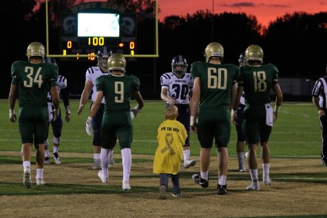 West Highs 2018 gold out game kid captain, Otto, walks onto the field for the coin toss.