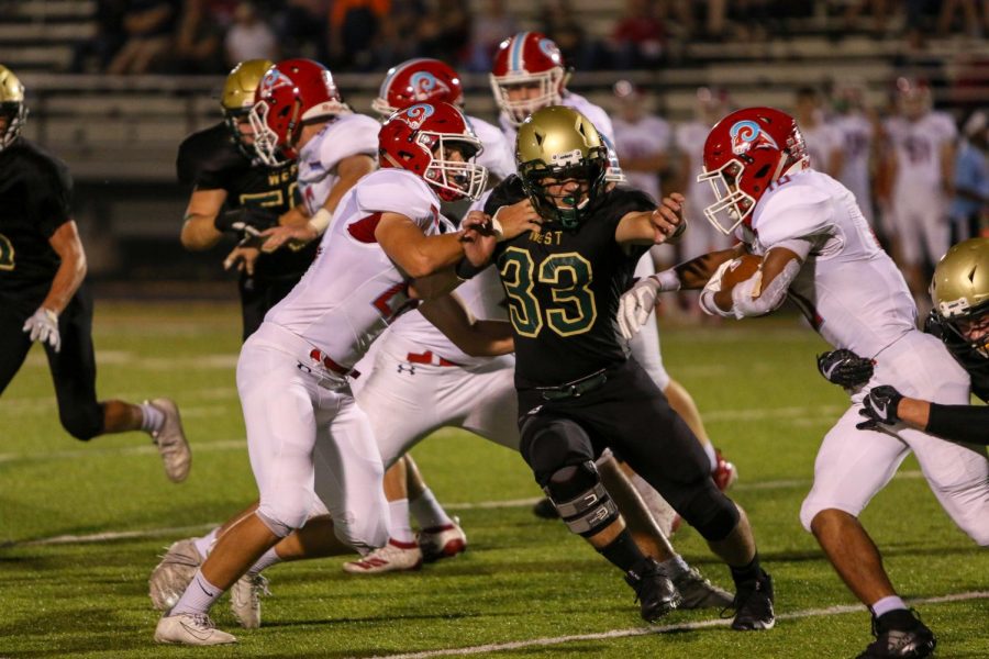 Will Hoeft 20 tries to make a tackle while holding off blocks during the teams game against Dubuque Senior at Trojan Field on Sept. 20.