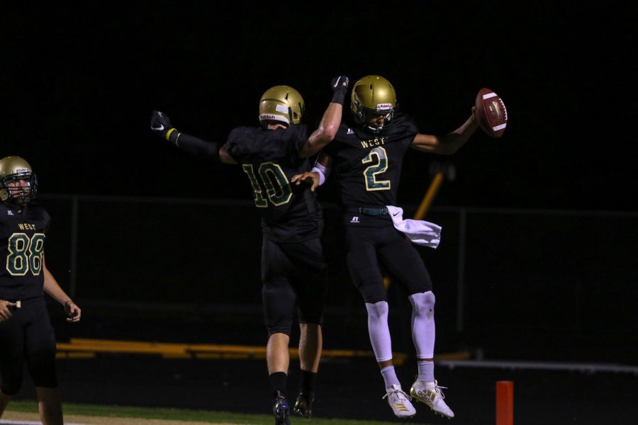 Marcus Morgan '21 and Tate Crane '20 celebrate a touchdown in the end zone on Sept. 20 during the game at Trojan Field.