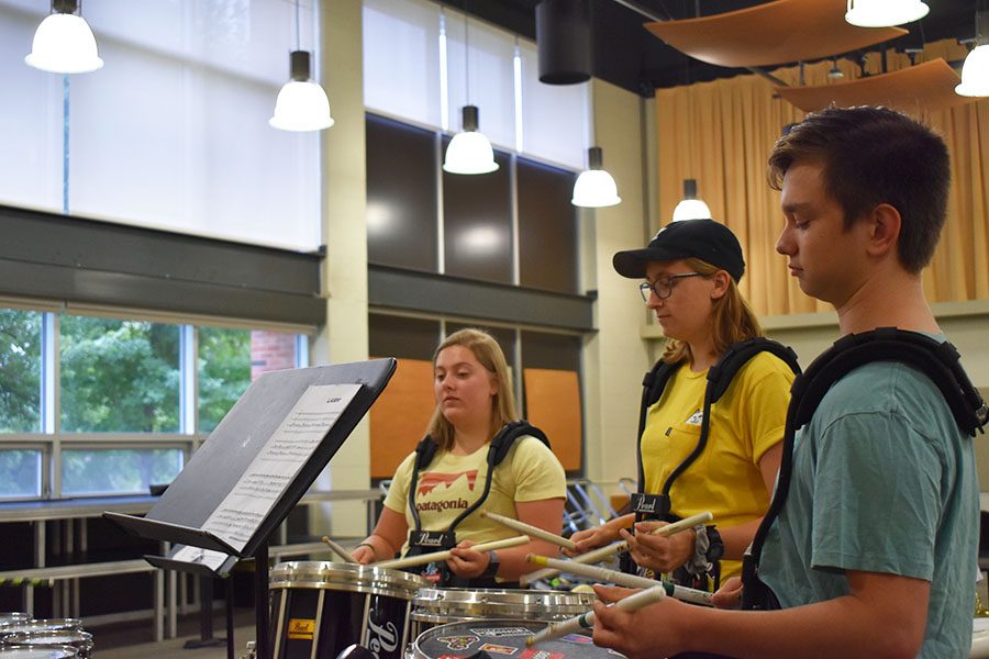 Noah Miller 21, Emily Hill 20 and Emma Christopher 22, members of the West High drumline play a cadence in the north band room. 