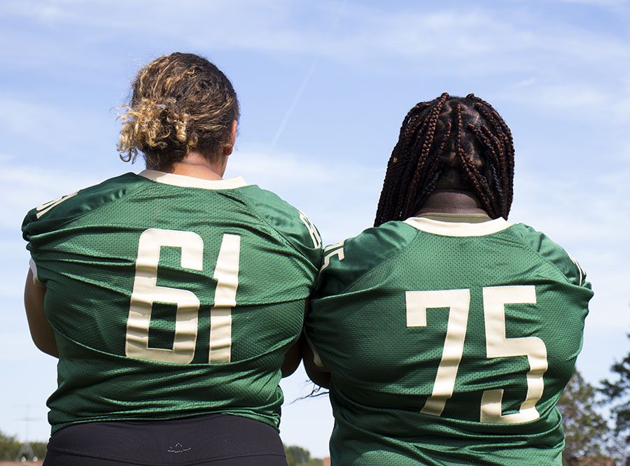 Phoebe Burt 21 and Salima Omari 20 stand side by side as the only two girls on the football team.
