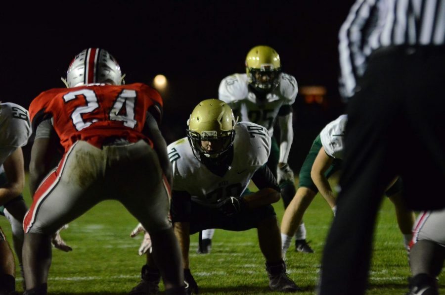 Right guard Fred Syata '21 eyes City High linebacker Tonka Hickman '20 before a play in the Battle for the Boot at Bates Field on Oct. 25.