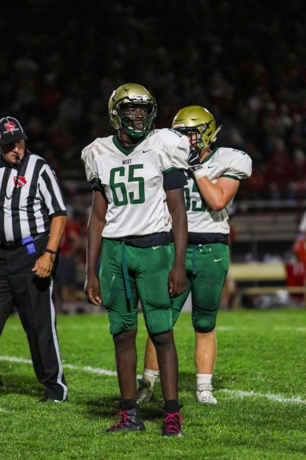 Anu Dokun '20 listens to his coach before a big third down play at North Scott on Aug. 30. Dokun recorded 5.5 tackles, 2.5 tackles for loss and 1.5 sacks in the game.