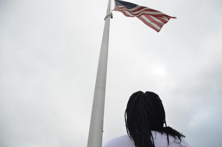 Reporter Mariam Keita 20 stands at the flagpole outside of West.