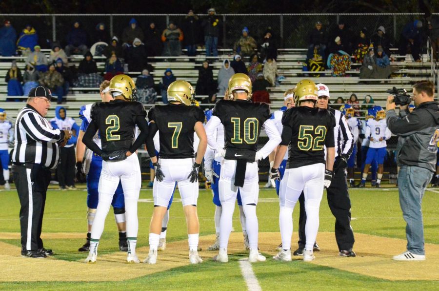 Team captains Marcus Morgan '21, Grant Henderson '20 and Tate Crane '20 gather for the coin toss at midfield before the Trojans' game against Davenport North at Trojan Field on Oct. 11. 