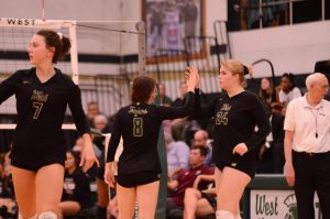 Setters Kearsten Lenth 22 and Emma Dunlap 22 encourage their teammates after scoring a point against Waterloo West on Sept. 29.