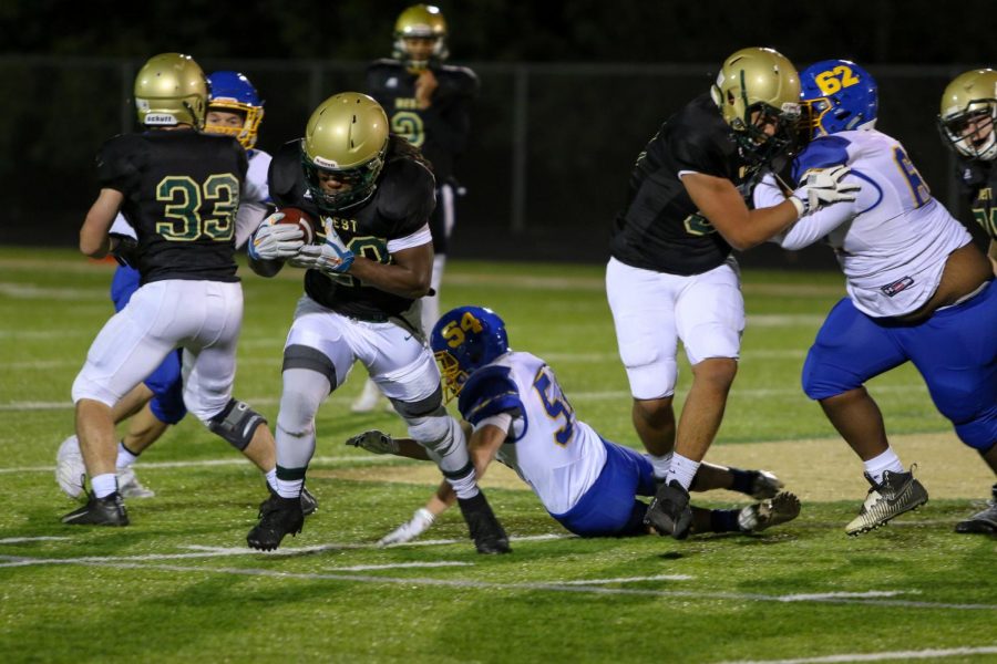 Marchaun Hoover '20 pushes past defenders in the second half of the Trojans' game against Davenport North at Trojan Field on Oct. 11. Hoover has been stymied at times this season in the backfield, but was able to score the game-winning touchdown on the team's final drive.