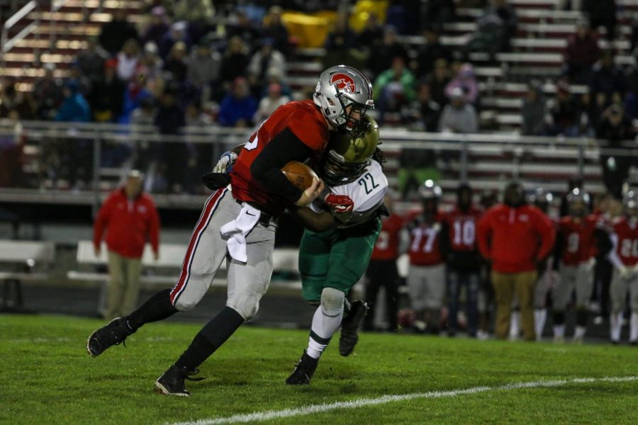 Marchaun Hoover '20 drags City High quarterback Raph Hamilton '21 to the ground in the second quarter of the Battle for the Boot at Bates Field on Oct. 25.