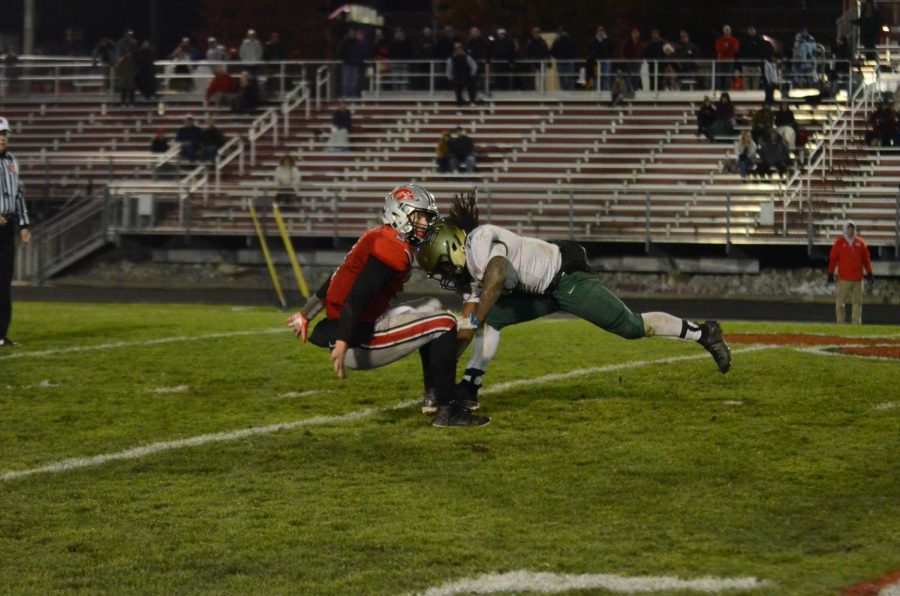 Marchaun Hoover '20 hits City High quarterback Raph Hamilton '21 in the Battle for the Boot at Bates Field on Oct. 25.