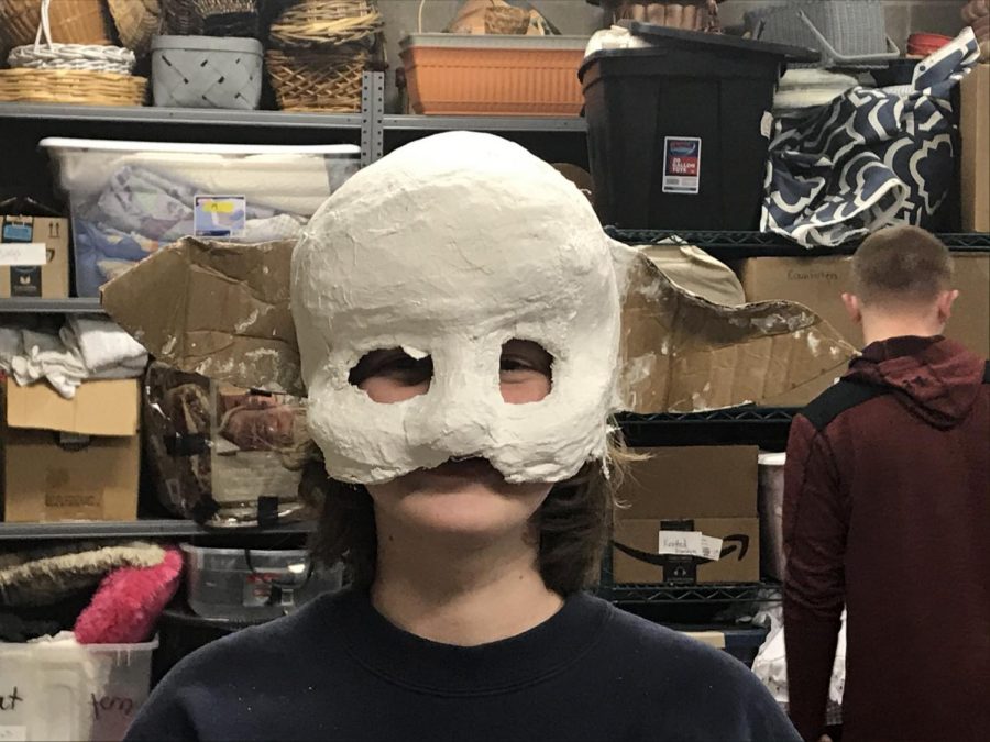 Kaylee Gibson 23 models a monster mask to insure a correct fit before an after school props meeting.