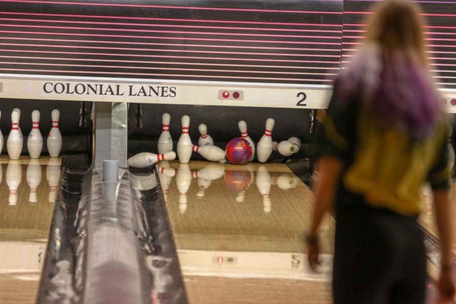 Jade Ritchey '22 watches as her bowl knocks down eight pins on Nov. 26 at Colonial Lanes against City High.