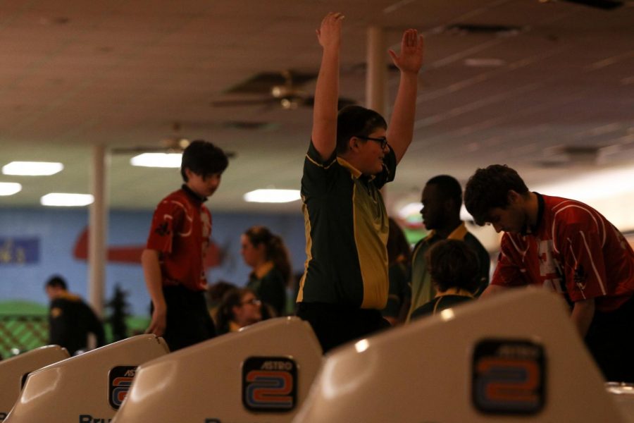 Alexander Rohm '22 celebrates a strike with teammates on Nov. 26 at Colonial Lanes against City High.