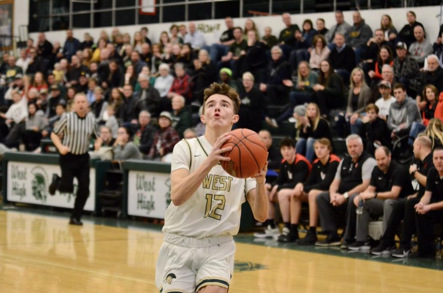 Joe Goodman ‘20 runs down court with no defenders in the way, scoring a layup against Linn-Mar on Dec. 20.