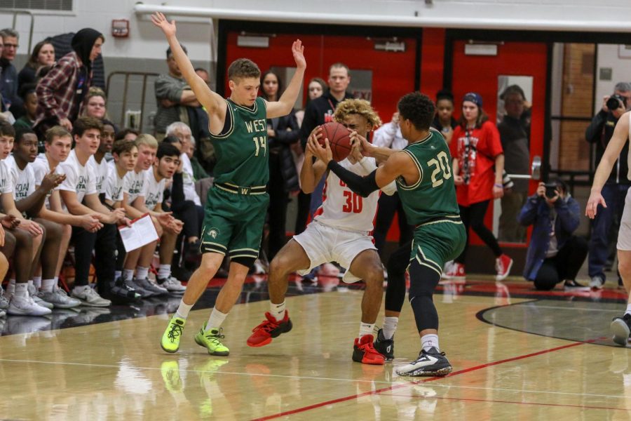 Marcus Morgan '21 reaches for a steal in the first quarter against City on Dec. 14.