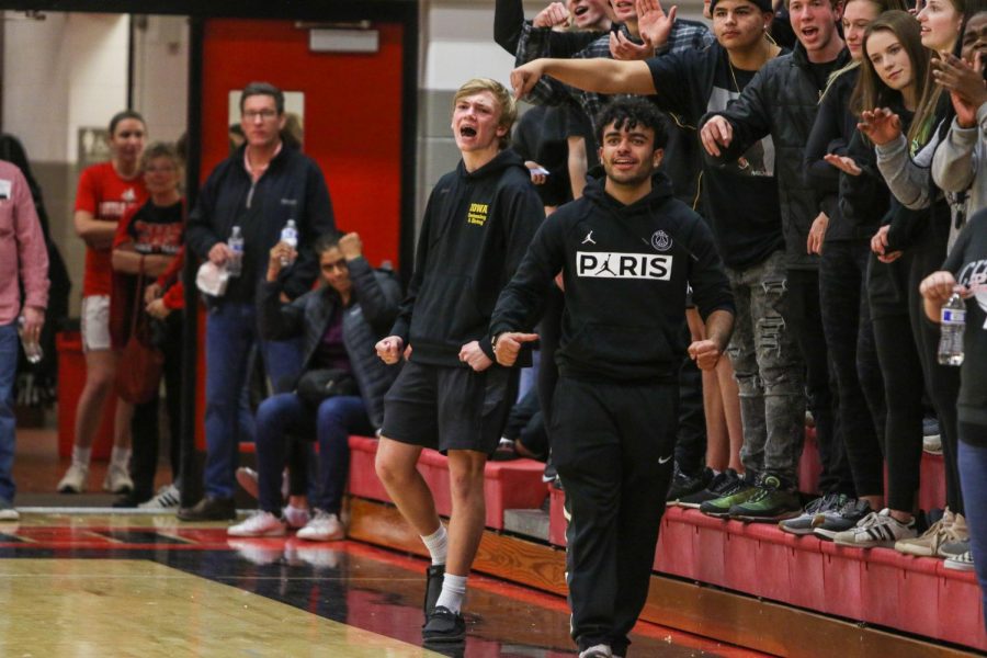 Student section members Grant Henderson '20 and Ali Alwahdani '20 celebrate an and one against City on Dec. 14. 