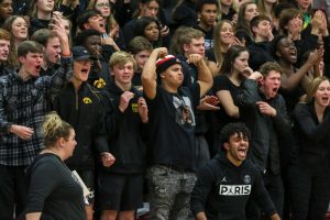 Makhi Halvorsen 20 and student section members celebrate senior Even Brauns and-one against City on Dec. 14.