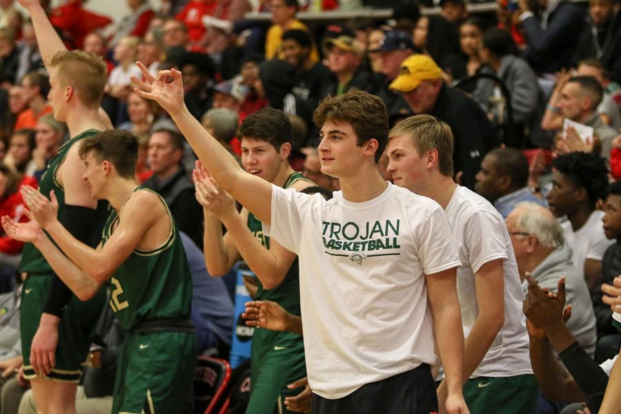 Grahm Goering '21 celebrates a three-pointer from the bench against City on Dec. 14. 