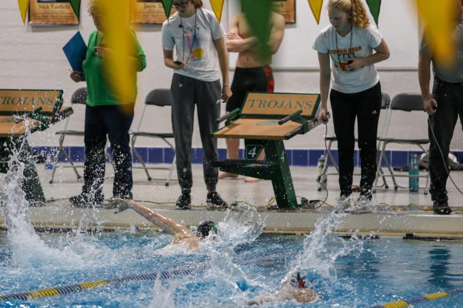 A Trojan Bolt swimmer reachers for the wall as timers watch during a dual swim meet against Linn-Mar on Dec. 17.