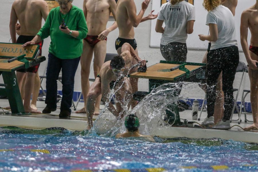 Body Skelley '22 celebrates his relay team's win with the team's final swimmer during a dual swim meet against Linn-Mar on Dec. 17.