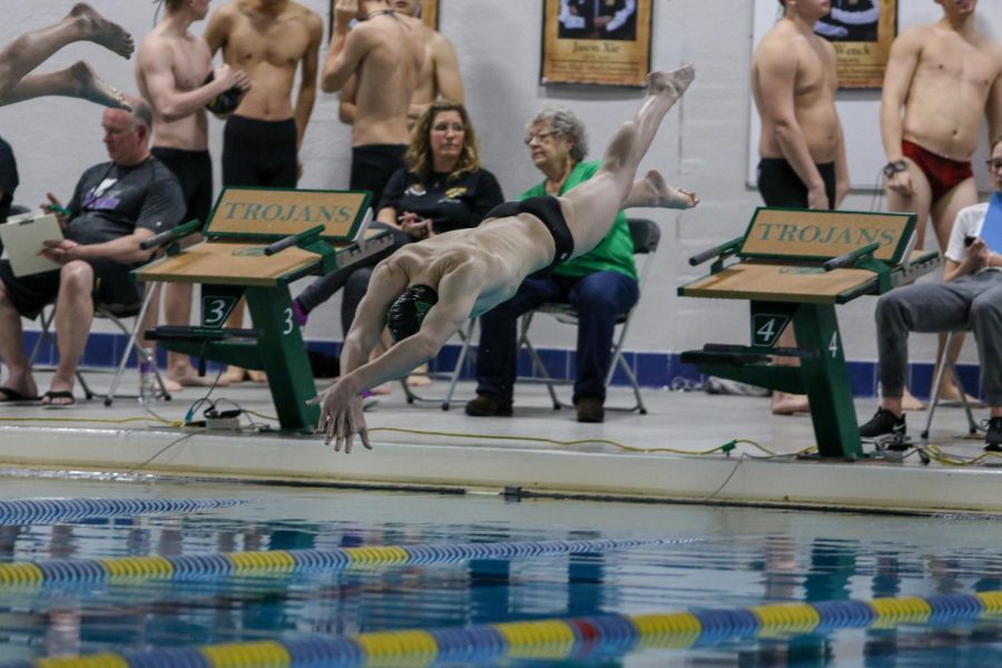 Jordan Christensen '22 dives in at the start of his race during a dual swim meet against Linn-Mar on Dec. 17.