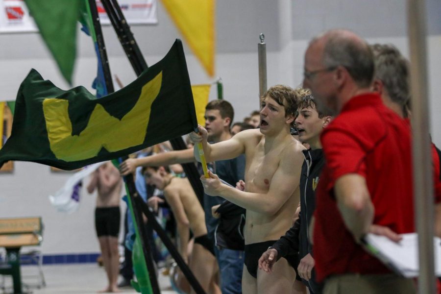 Jordan Christensen 22 cheers on the Trojan Bolts during a dual swim meet against Linn-Mar on Dec. 17.