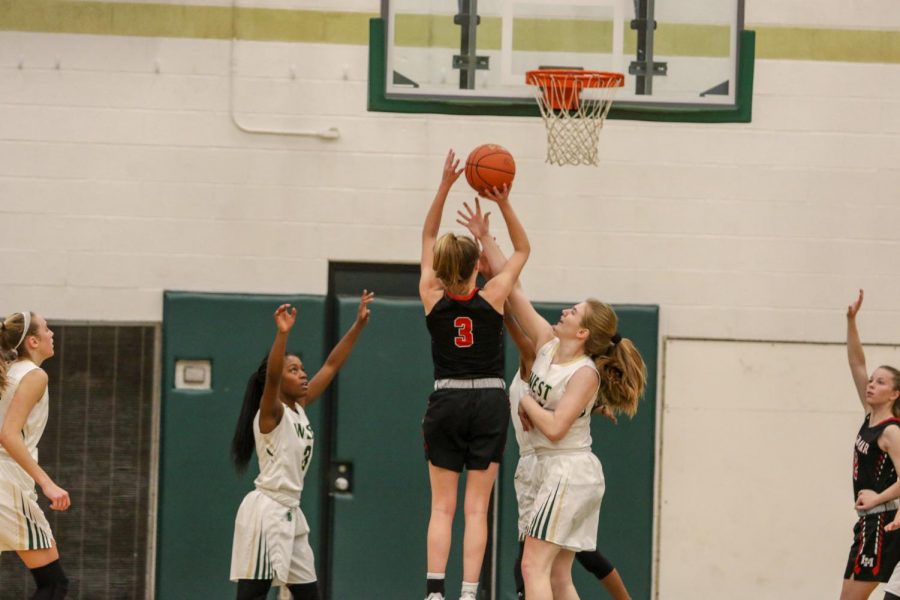 Anna Prouty '23 reaches for a block against Linn-Mar on Dec. 20.