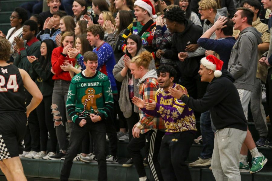 Student section members celebrate one of senior Even Brauns' dunks against Linn-Mar on Dec. 20.