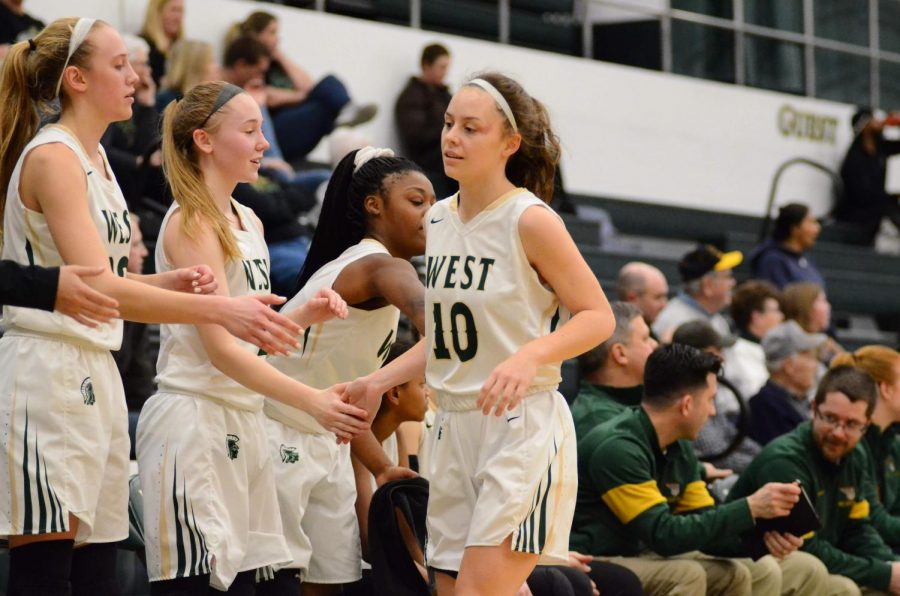 Sophomore Avery Vest high fives her teammates after being subbed out of the game. This was Vest's first game off injury.