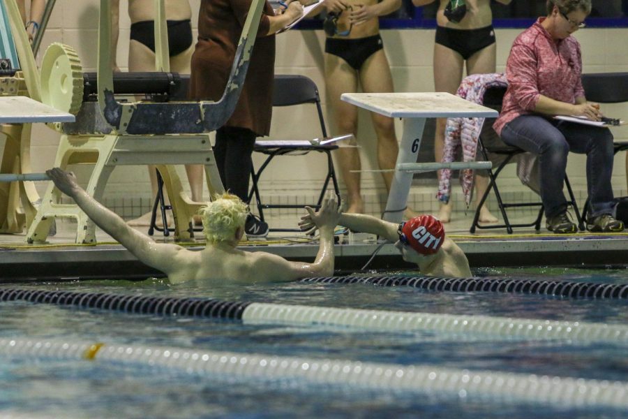 James Pinter '20 shakes hands with his City High opponent after winning the 100-yard backstroke on Jan. 21.