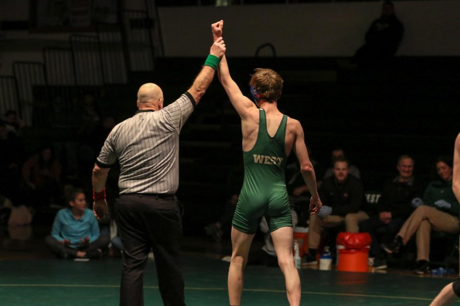 The referee raises the hand of Drake Davis 22 after his dramatic victory at 145 pounds.