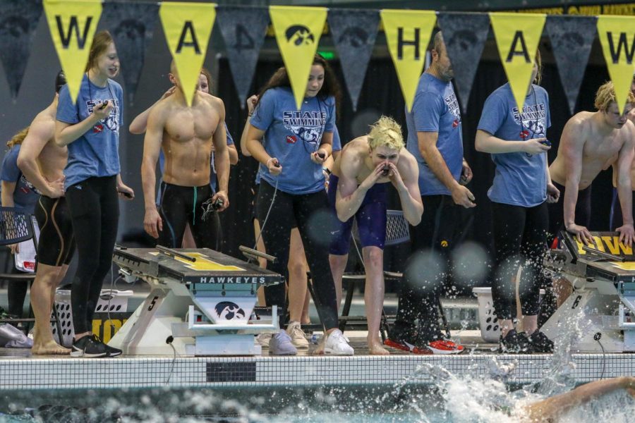 Diggory Dillingham '23 cheers on the 400 yard freestyle relay's last swimmer on Feb. 15. The team finished second in the state with a time of 3:05.45.