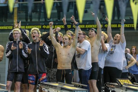 Izaak Hajek 20, along with his teammates and coaches, celebrate as Jordan Christensen 22 recieves his medal on Feb. 15. 