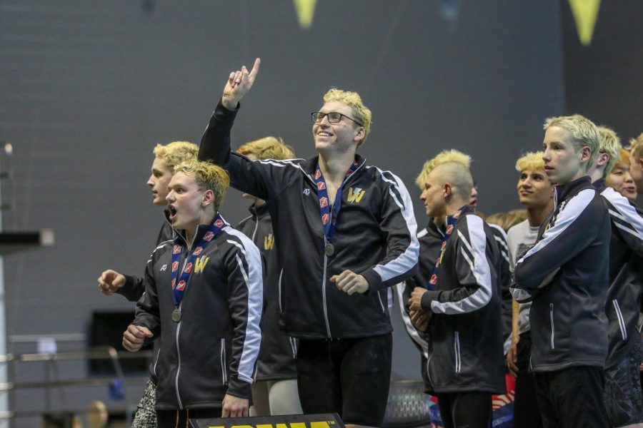 James Pinter '20 looks up to the crowd holding up number one as his team is announced as state champions on Feb. 15.