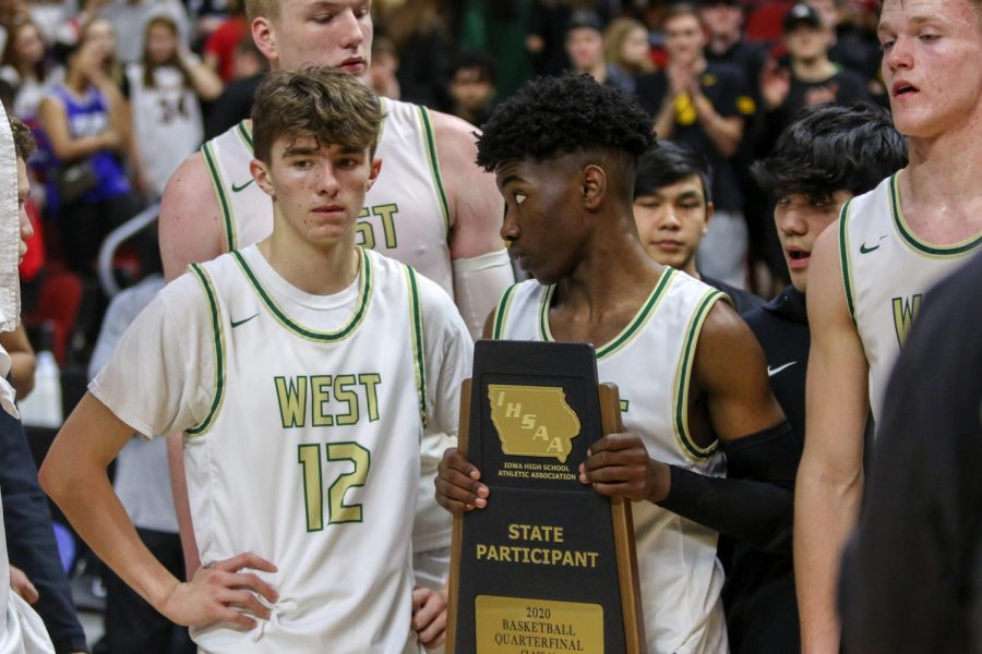 Joe Goodman '20 and Christian Barnes '22 receive the teams trophy after the state quarterfinal on March 11.