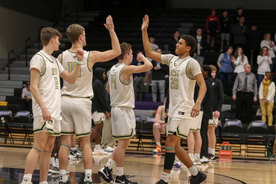 Marcus Morgan '21 high fives Tate Crane '20 during starting lineups against Pleasant Valley on March 3.