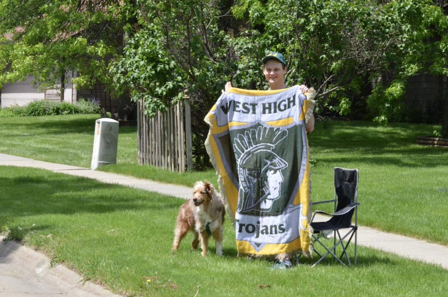 English teacher John Boylan congratulates the seniors by holding up a West High blanket.