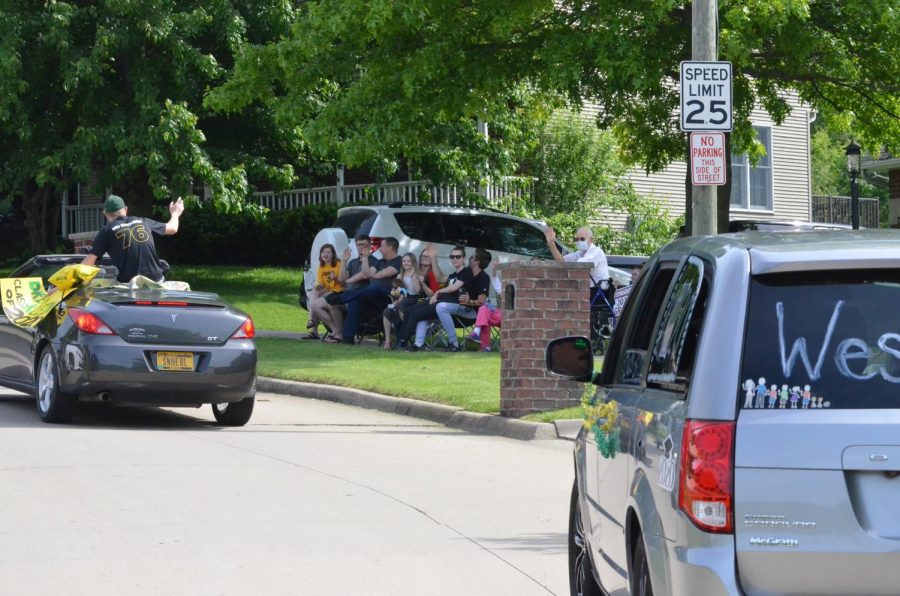 Families in the neighborhood wave to the seniors during the car parade on May 31.